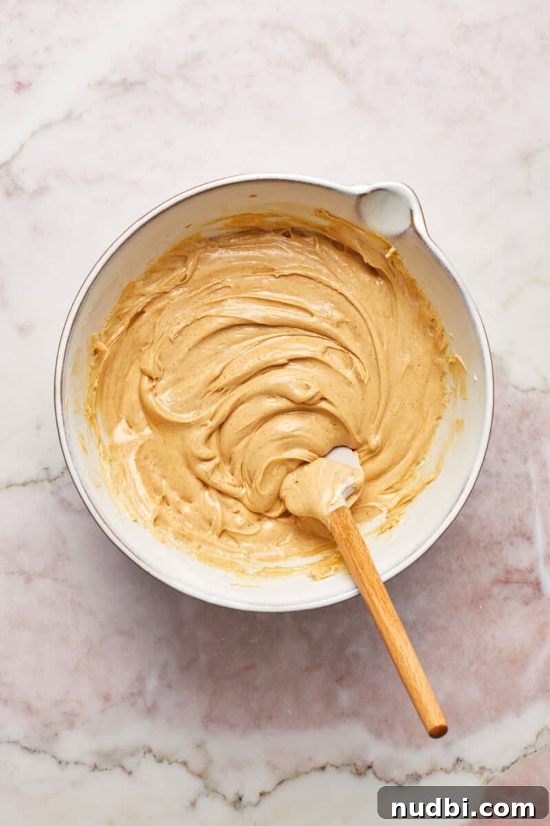 Quick Microwave Peanut Butter Fudge Recipe 6 Mixing bowl with microwave peanut butter fudge mixture and spatula.