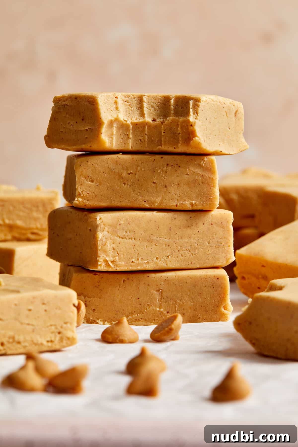 Quick Microwave Peanut Butter Fudge Recipe 9 Stack of cut microwave peanut butter fudge pieces with top piece bitten into.