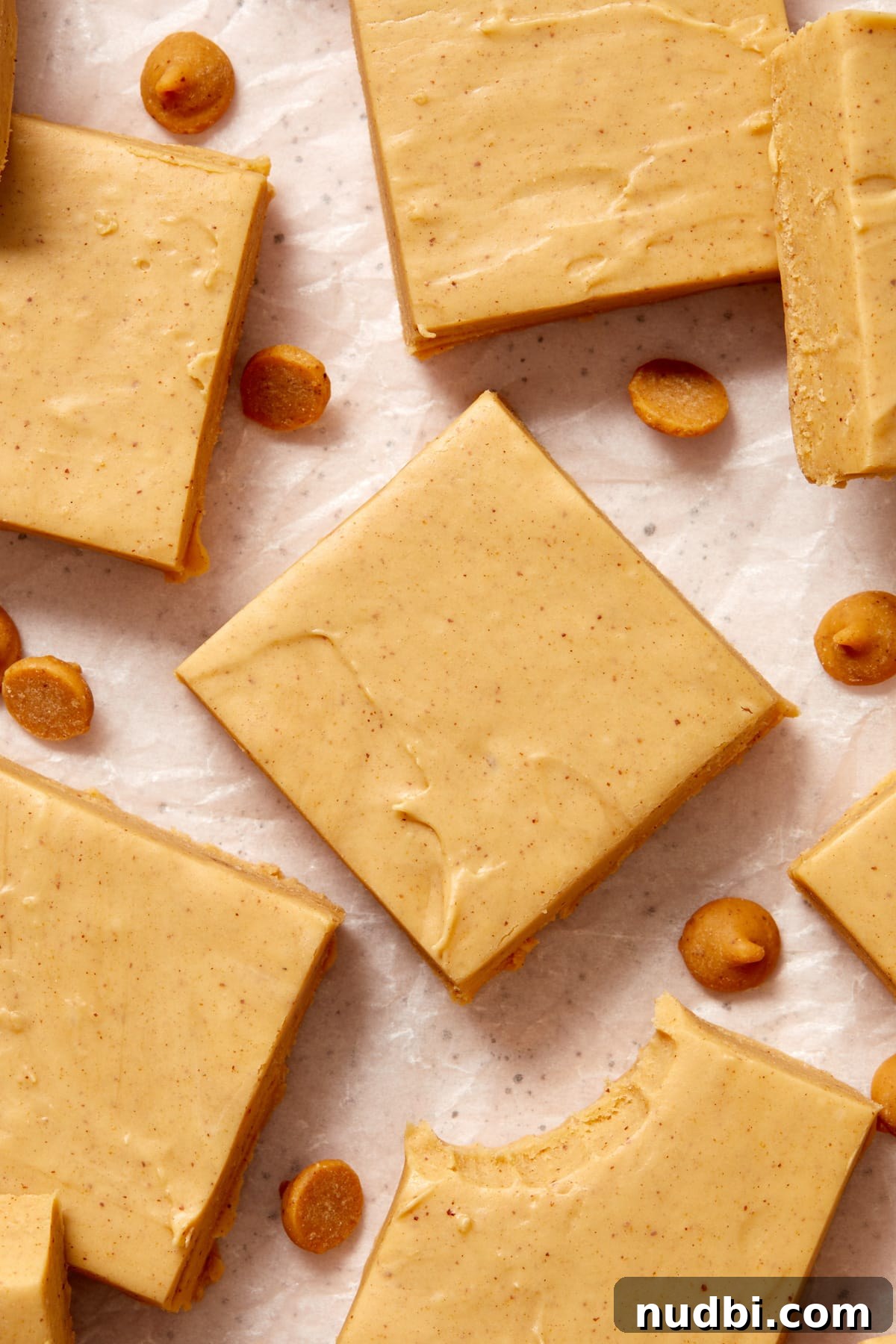 Quick Microwave Peanut Butter Fudge Recipe 10 Squares of peanut butter fudge on wax paper with peanut butter chips.