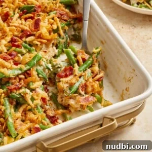 Bacon and green bean casserole in pan with serving spoon.