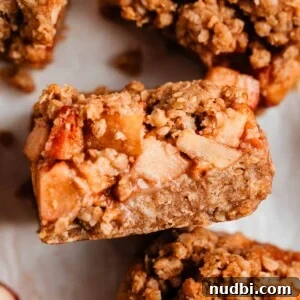 Apple crumble bar propped on surrounding sliced bars.