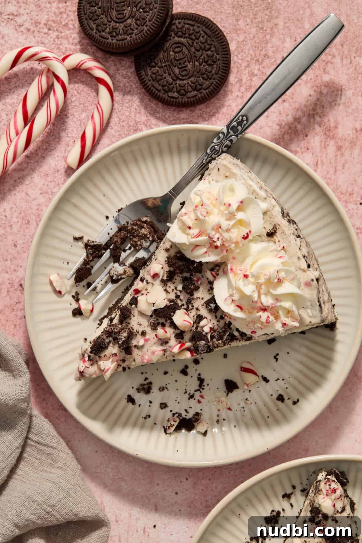 No‑Bake Peppermint Oreo Cheesecake Recipe for the Holidays 19 Plate with slice of peppermint Oreo cheesecake with fork on plate.