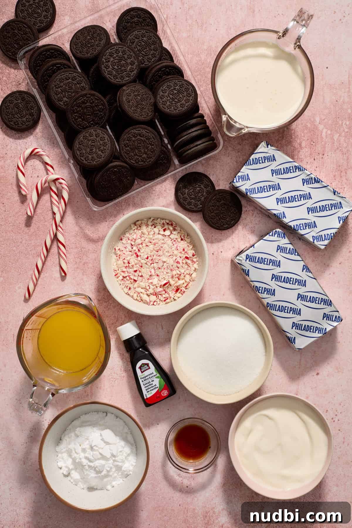 No‑Bake Peppermint Oreo Cheesecake Recipe for the Holidays 4 Oreos, cream cheese, peppermint extract, candy canes, cream and other ingredients measured and arranged on surface.