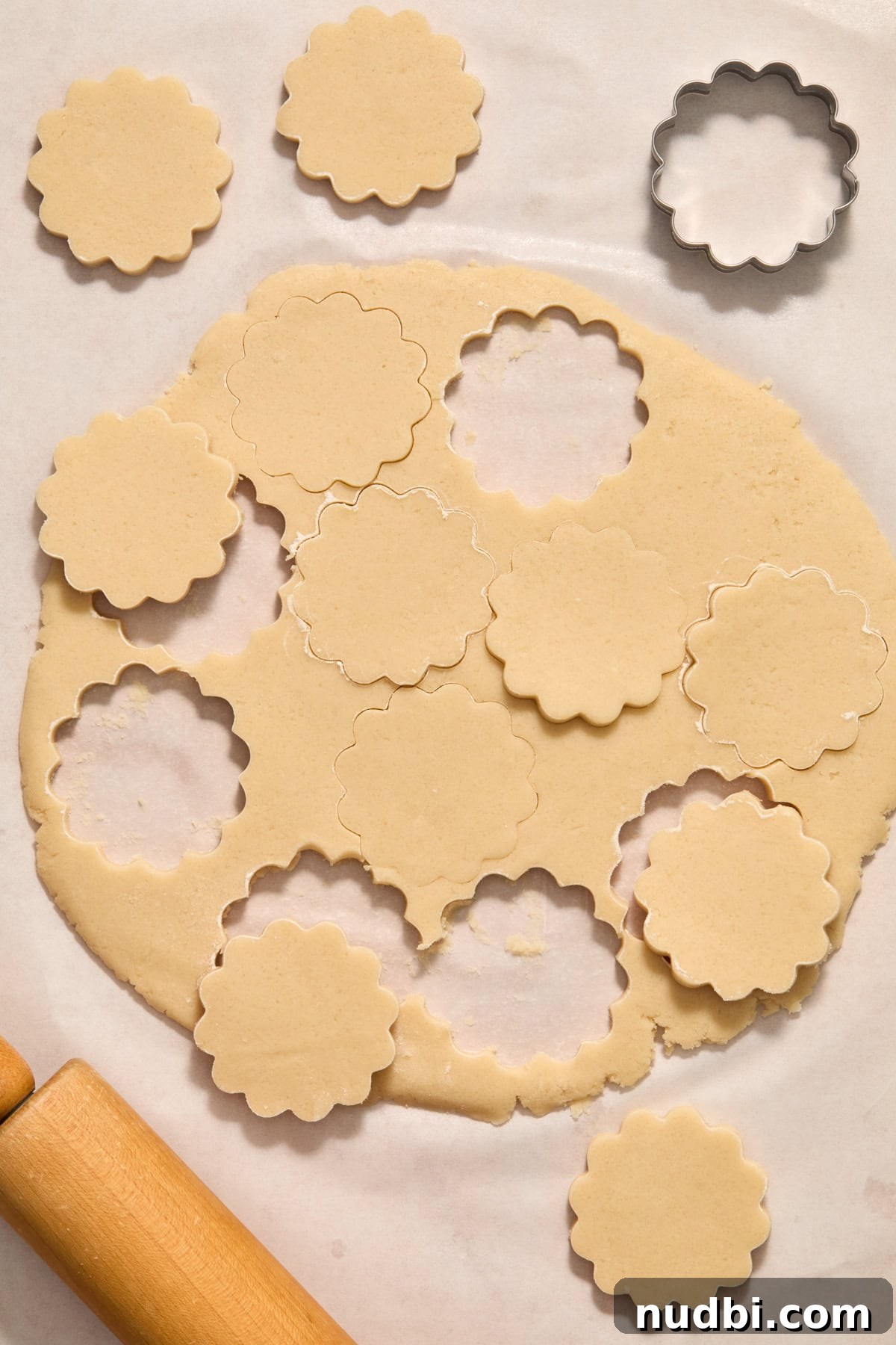 Soft and Chewy Eggless Sugar Cookies Recipe 10 Rolled cookie dough with scalloped cookie cutter shapes.