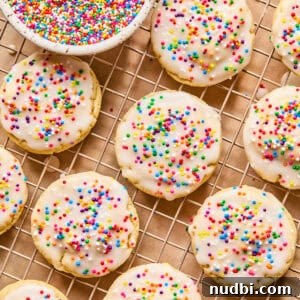 Top Christmas Cookie Recipes to Bake This Holiday Season 27 Iced sugar cookies on wire rack with sprinkles.