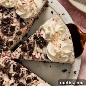 Peppermint Oreo cheesecake slice on spatula before being pulled from the pie dish.
