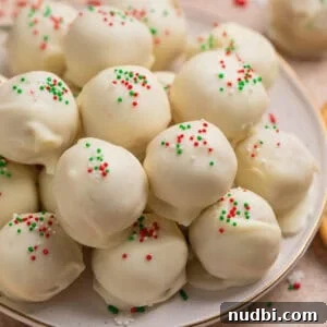 Plate with white chocolate covered Christmas Oreo cookie truffles topped with red, white and green sprinkles.