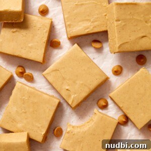 Microwave peanut butter fudge cut into squares and arranged on wax paper.