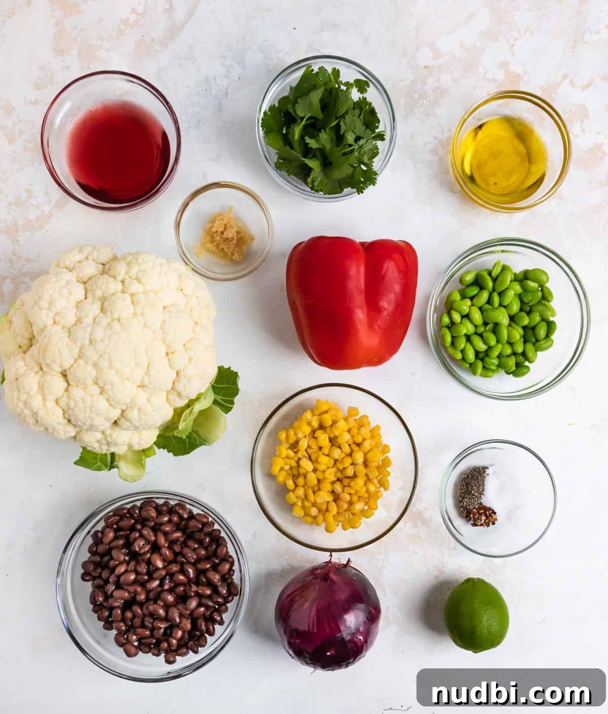 Black Bean & Cauliflower Rice Salad with Zesty Lime Dressing 3 Cauliflower, corn, black beans, peppers, lime and other ingredients on counter.