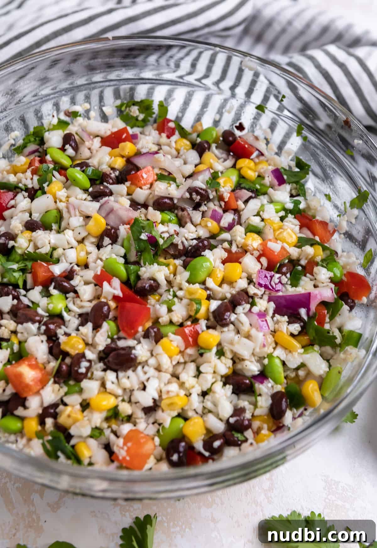 Black Bean & Cauliflower Rice Salad with Zesty Lime Dressing 5 Tossed cauliflower black bean salad in glass bowl.