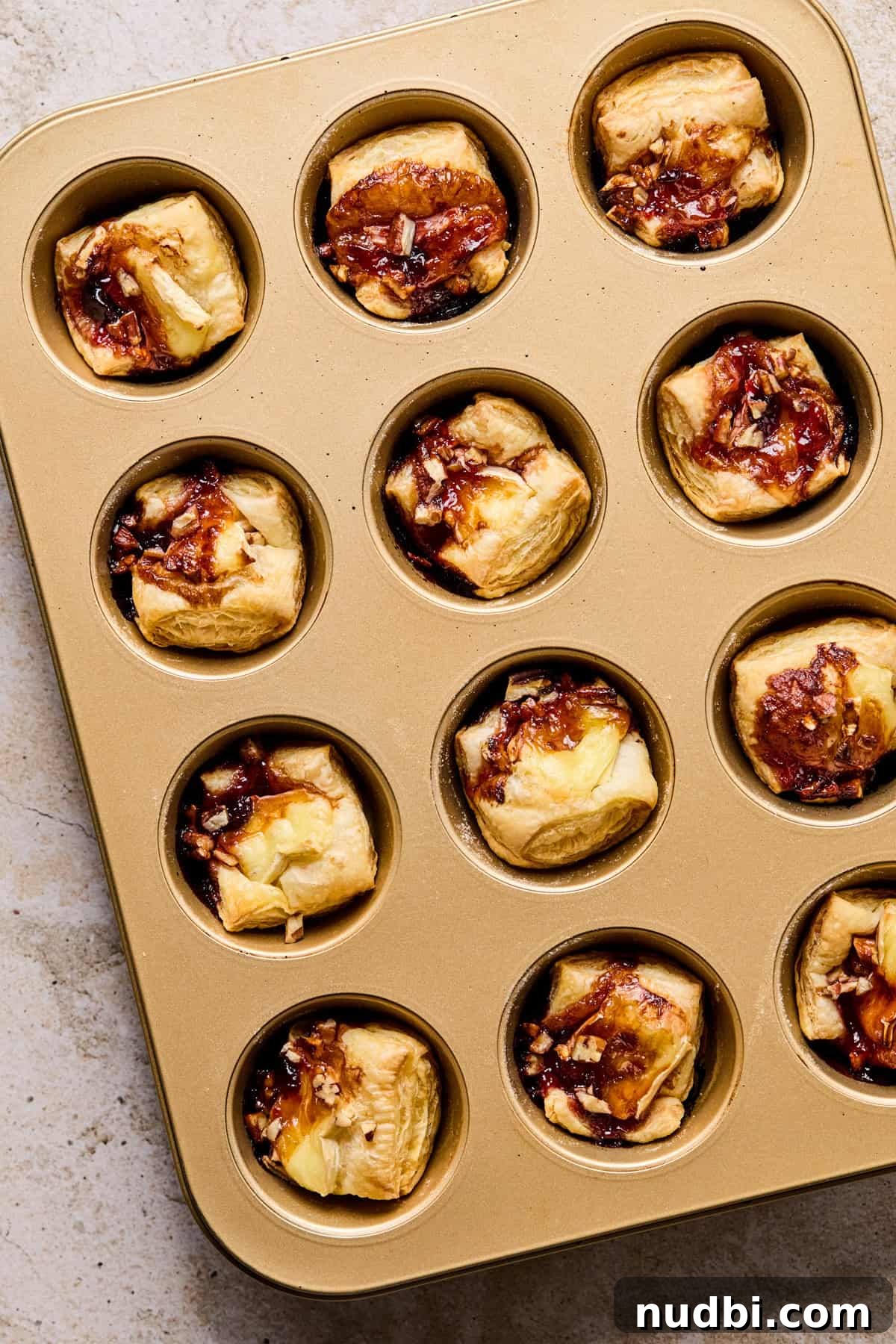 Melted Brie Puff Pastry Bites with Honey & Thyme 7 Muffin tin with baked brie bites in puff pastry.