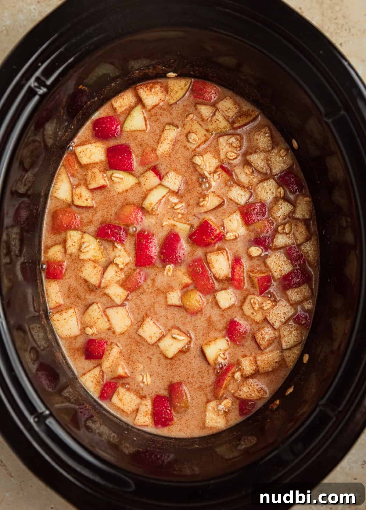 Slow Cooker Apple Cinnamon Oatmeal Recipe for Breakfast 5 Liquid added to oats and apples in crockpot before cooking.