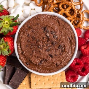 Festive Holiday Appetizers and Party Snacks Guide 21 White bowl with chocolate brownie batter hummus on plate with berries, graham crackers and other dippers.