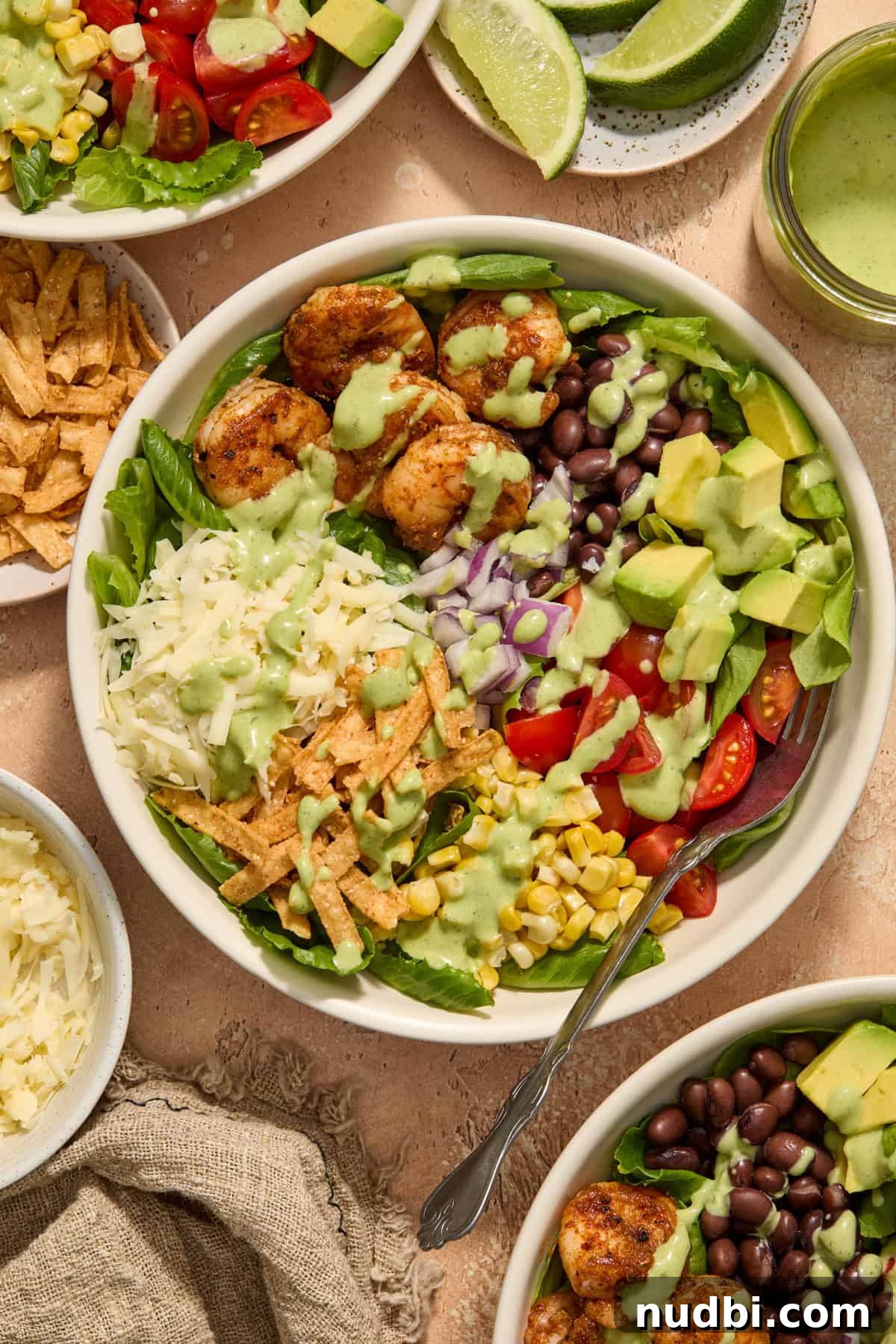 Shrimp Taco Salad with Creamy Cilantro-Lime Dressing 2 Overhead view of shrimp taco salad in bowl with seasoned shrimp, corn, avocado, cheese and more.