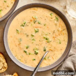 30-Minute Dinner Recipes You'll Love 14 Gray ceramic bowl with broccoli cheddar soup served with spoon.