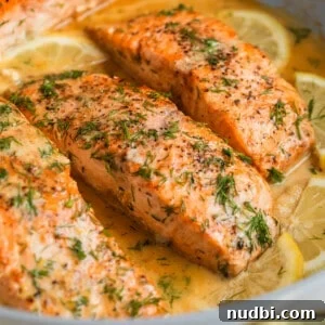 30-Minute Dinner Recipes You'll Love 18 Lemon dill seared salmon in skillet with extra chopped dill on top and lemon slices.