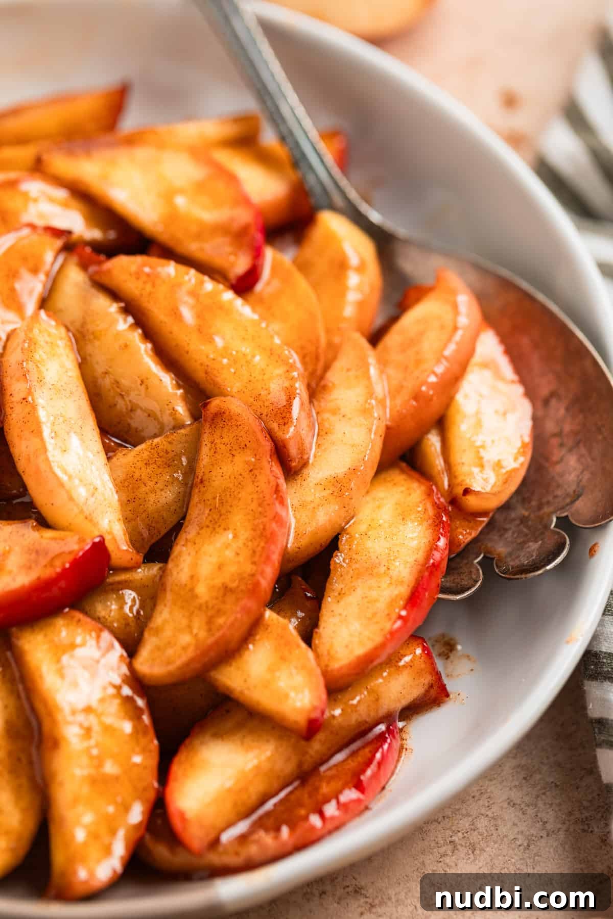 Crispy Caramelized Apples in the Air Fryer 8 Air fried apples on serving dish with spoon.