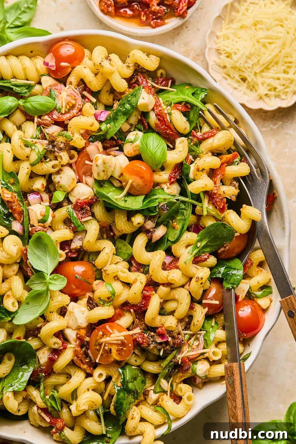 Sun-Dried Tomato Pasta Salad with Fresh Basil & Feta 2 Sun dried tomato pasta salad topped with chopped basil and spoon and fork propped in the bowl.