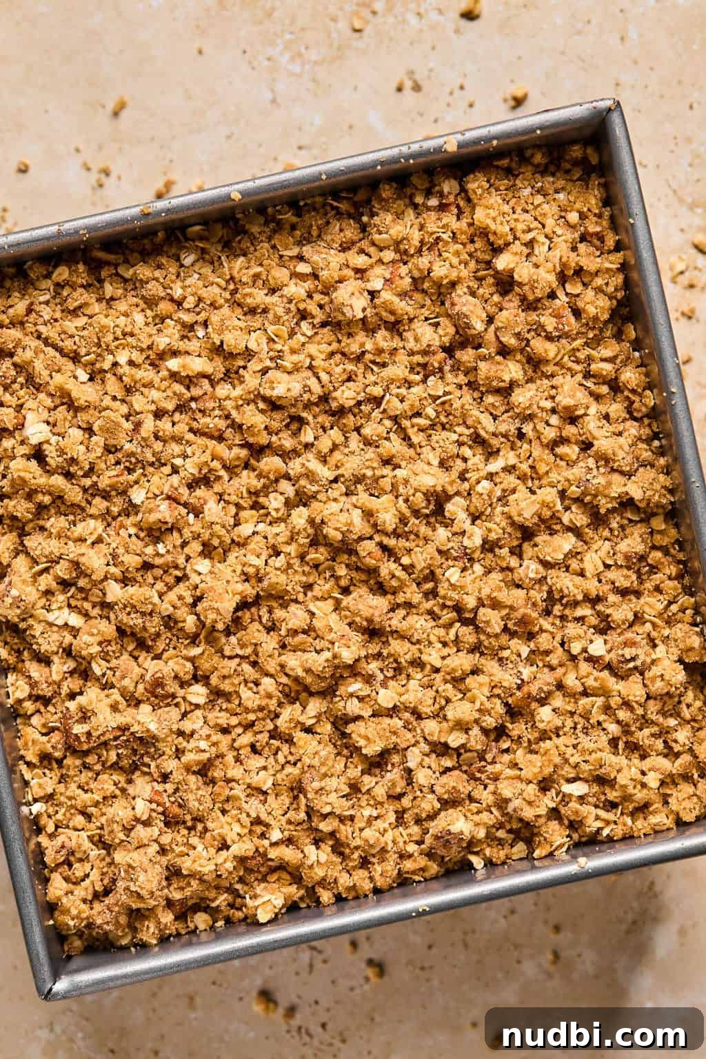 Ultimate Pumpkin Pie Crumble Recipe with a Buttery Streusel Topping 9 Pumpkin crisp in pan with oat topping covering pumpkin layer before baking.