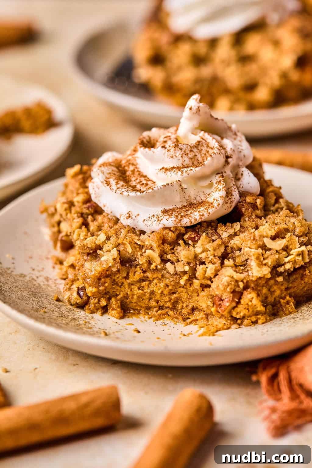 Ultimate Pumpkin Pie Crumble Recipe with a Buttery Streusel Topping 11 Piece of pumpkin crisp on dish with portion eaten.