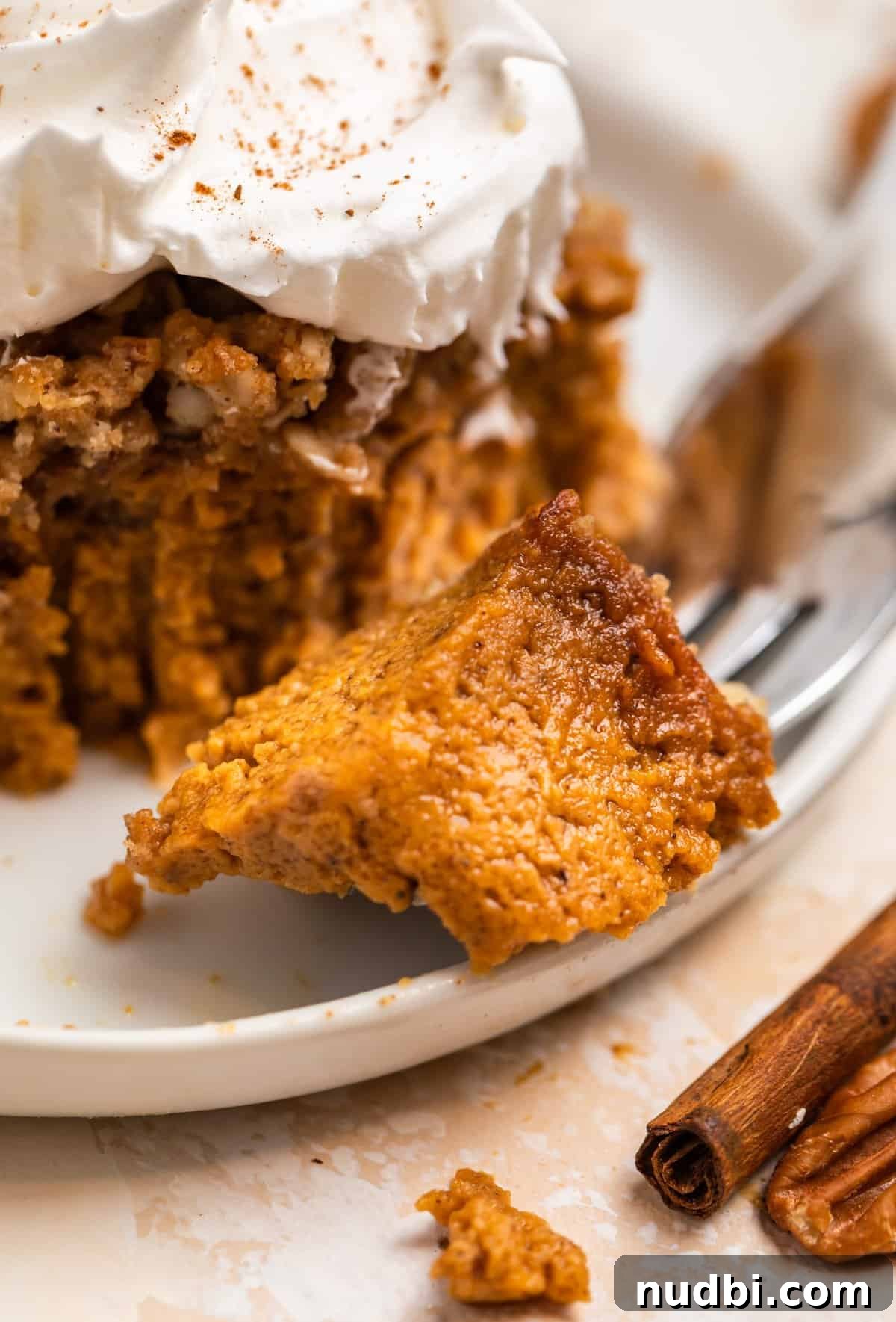 Ultimate Pumpkin Pie Crumble Recipe with a Buttery Streusel Topping 12 Fork with pumpkin crumble piece on it beside a slice of the dessert.