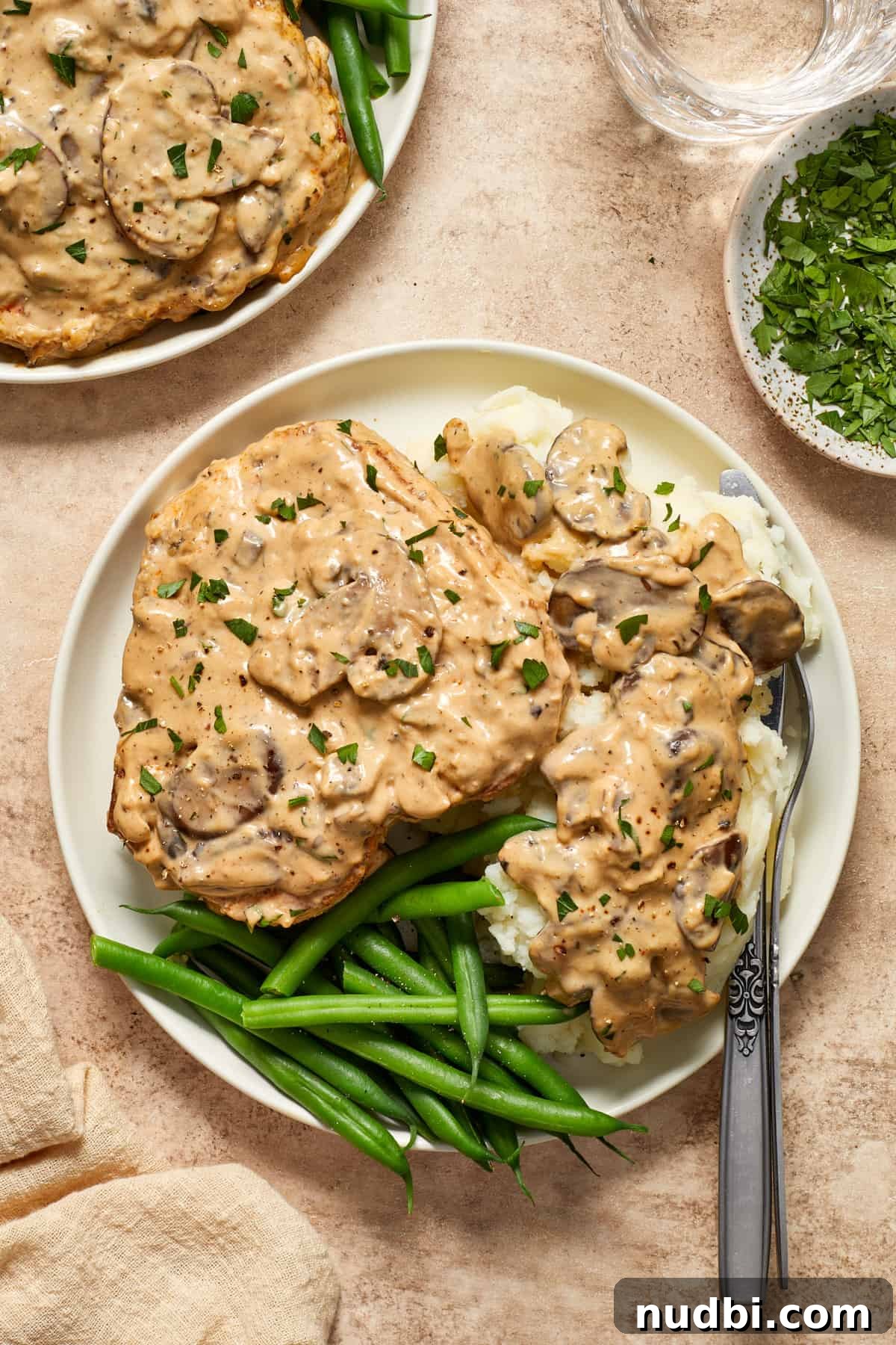 Creamy Mushroom Pork Chops with Garlic and Thyme 2 Cream of mushroom pork chop on mashed potatoes with fork
