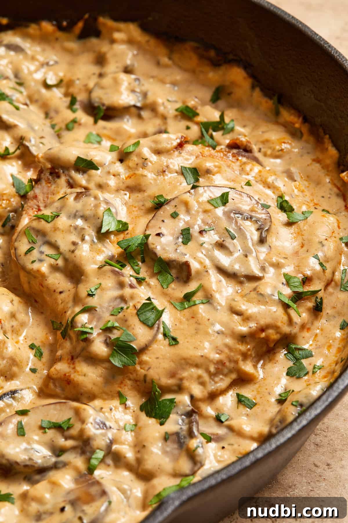 Creamy Mushroom Pork Chops with Garlic and Thyme 13 Skillet with cream of mushroom pork chops with parsley on top.
