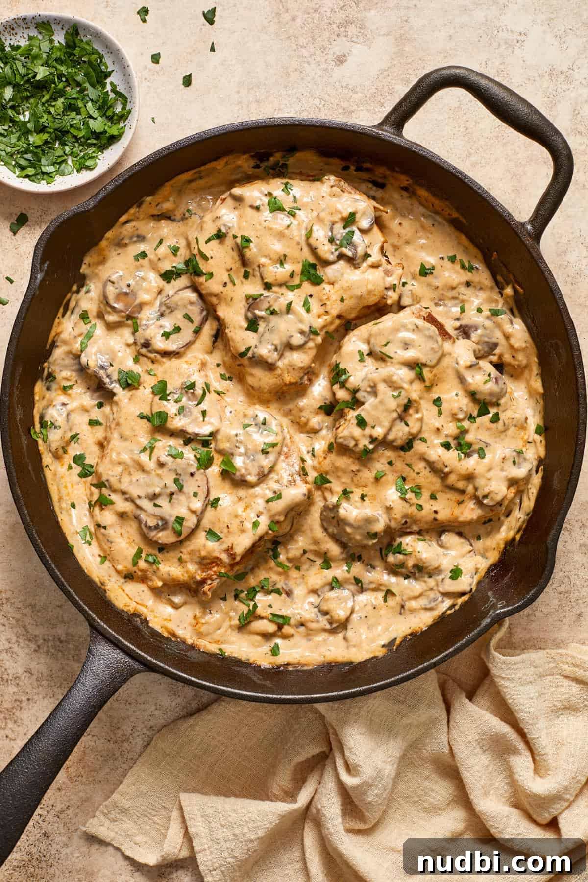 Creamy Mushroom Pork Chops with Garlic and Thyme 4 Overhead view of pork chops in cream of mushroom sauce with mushrooms on top.