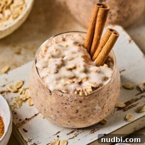 Creamy Overnight Oats Recipes for Quick Healthy Breakfasts 4 Overnight oats with cinnamon roll flavor in jar with icing drizzled over top.