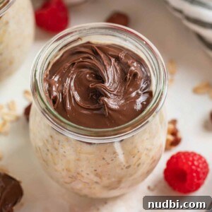 Creamy Overnight Oats Recipes for Quick Healthy Breakfasts 10 Jar of nutella overnight oats with raspberries beside it.