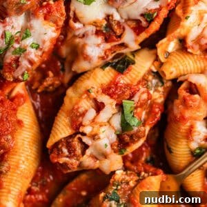 Cozy Dinner Recipes for Comforting Weeknight Meals 17 Ground beef stuffed shells in marinara with cheese and chopped basil over top.