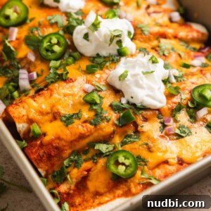 Cozy Dinner Recipes for Comforting Weeknight Meals 31 Ground turkey enchiladas in baking pan topped with sour cream, cilantro, onion and jalapeño.