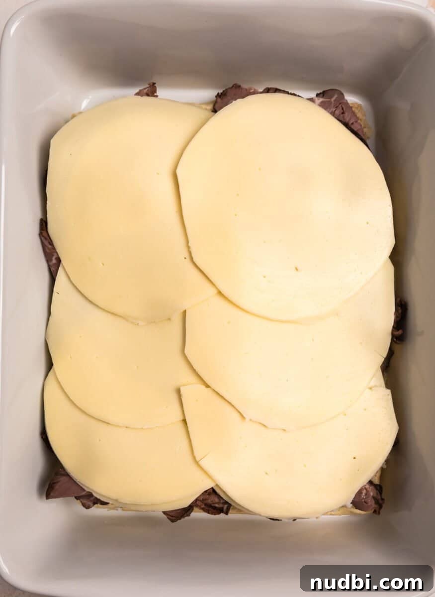French Dip Sliders Recipe with Savory Au Jus for Dipping 7 Provolone cheese slices on top of roast beef.