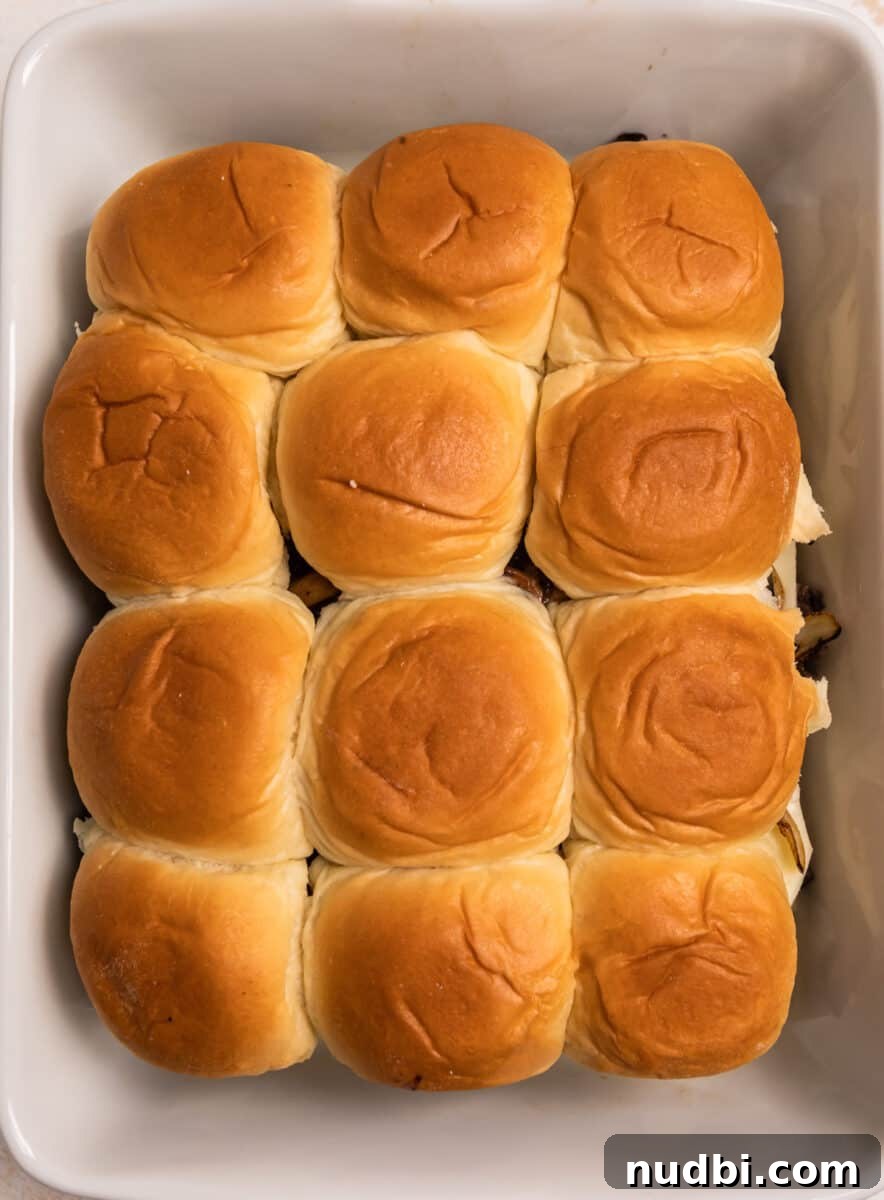 French Dip Sliders Recipe with Savory Au Jus for Dipping 9 Top layer of Hawaiian rolls on top of sandwiches in baking pan.