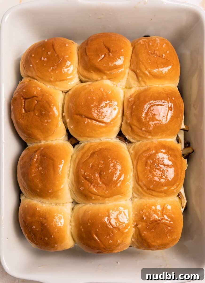 French Dip Sliders Recipe with Savory Au Jus for Dipping 10 Buttered tops of rolls in baking dish.