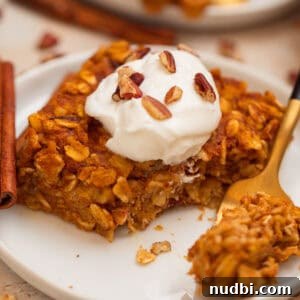 Slice of pumpkin oatmeal bake topped with yogurt and chopped pecans.