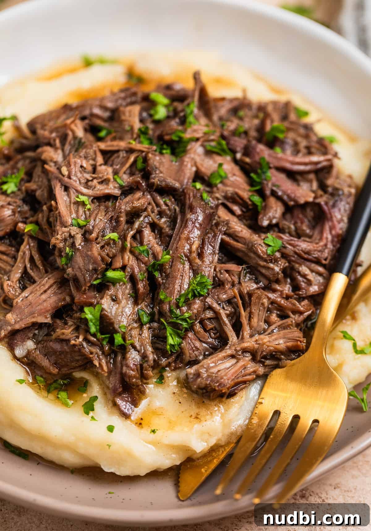 Slow-Cooker Shredded Beef Recipe for Tender, Flavorful Meals 2 Dish with mashed potatoes topped with crock pot shredded beef.