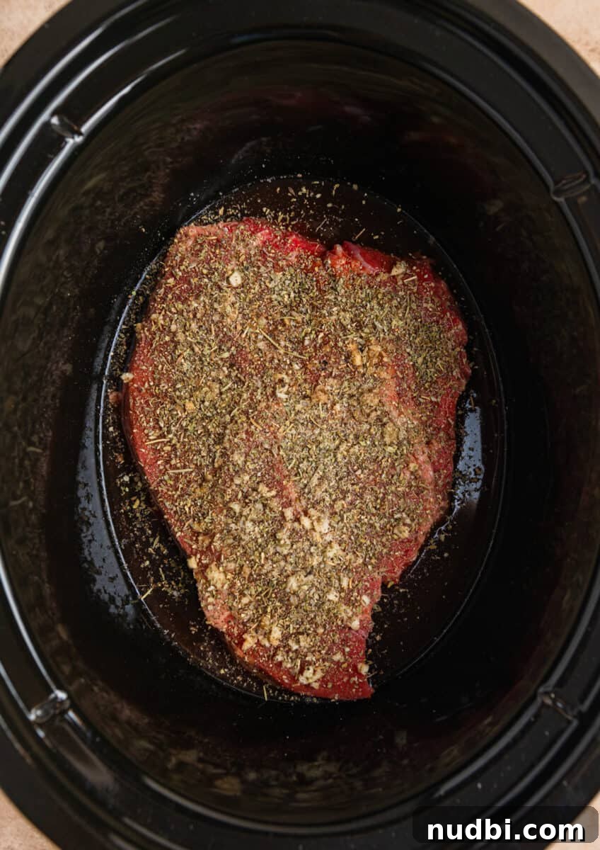 Slow-Cooker Shredded Beef Recipe for Tender, Flavorful Meals 6 Beef chuck roast in crockpot topped with seasoning.