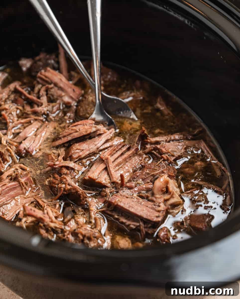 Slow-Cooker Shredded Beef Recipe for Tender, Flavorful Meals 8 Forks shredding crock pot shredded beef in slow cooker.