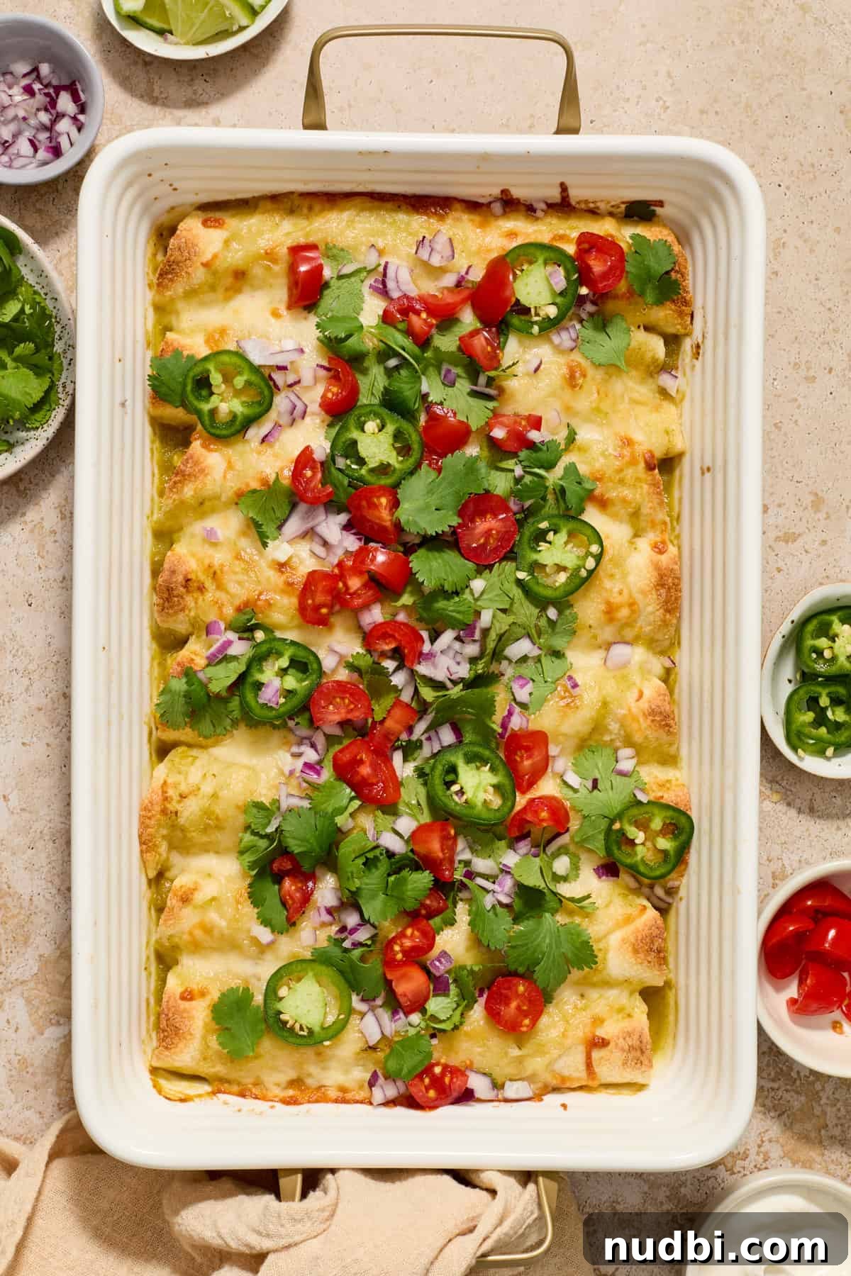 Authentic Green Salsa Chicken Enchiladas Recipe 2 Pan with chicken enchiladas in green sauce with melted cheese and chopped cilantro on top.