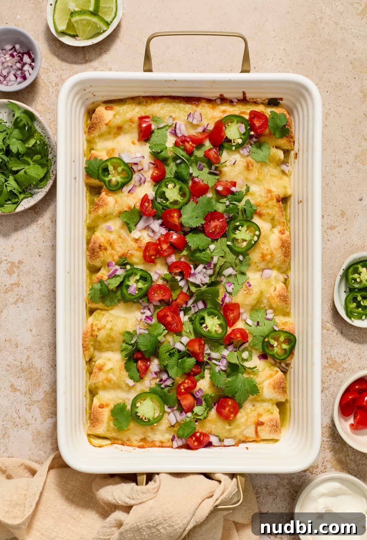 Authentic Green Salsa Chicken Enchiladas Recipe 11 Pan of enchiladas topped with tomatoes, onions, cilantro, and jalapeños.