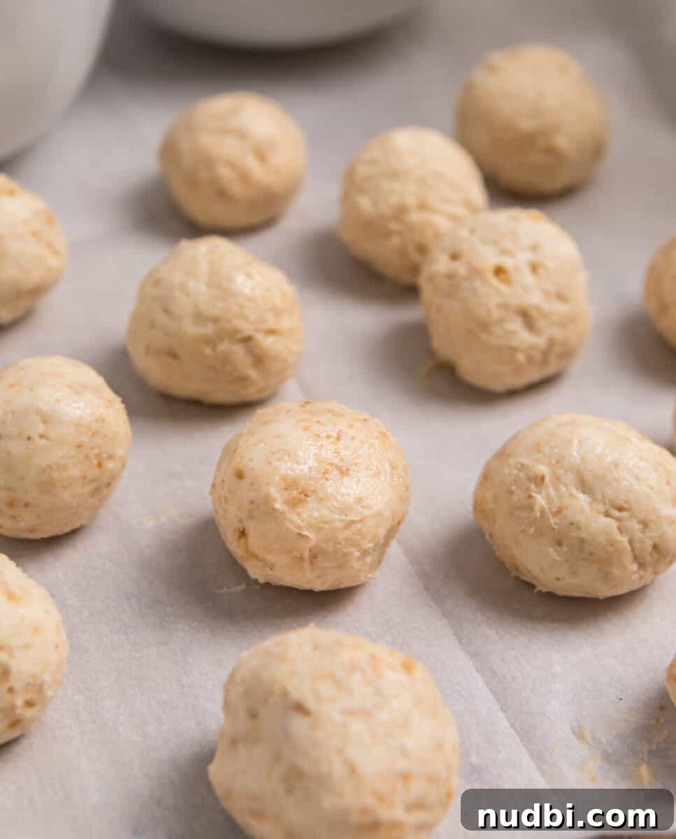 No-Bake Mini Cheesecake Bites: Easy Dessert Balls Recipe 7 No bake cheesecake bites rolled into balls on parchment.
