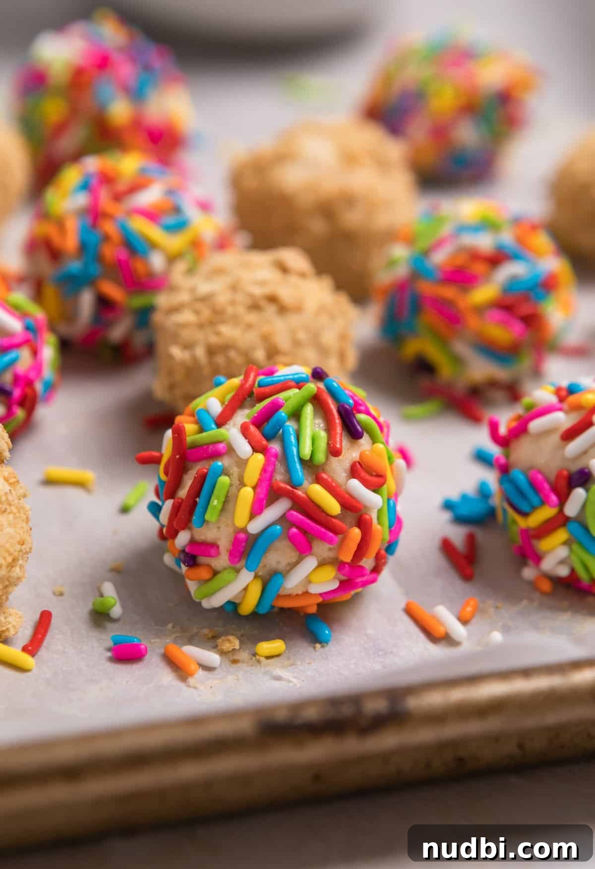 No-Bake Mini Cheesecake Bites: Easy Dessert Balls Recipe 10 Cheesecake balls rolled in sprinkles and graham crackers crumb.