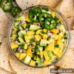 Mango and Avocado Salsa Recipe — Fresh Tropical Dip Guide 6 Overhead view of mango avocado salsa in bowl with chips.