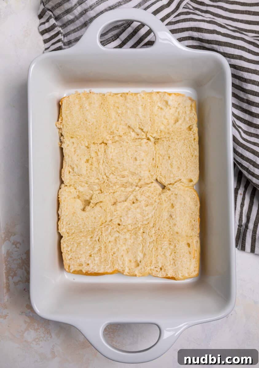 Classic Reuben Sliders with Melted Swiss and Tangy Sauerkraut 5 Hawaiian rolls halved in the bottom of a white baking dish.