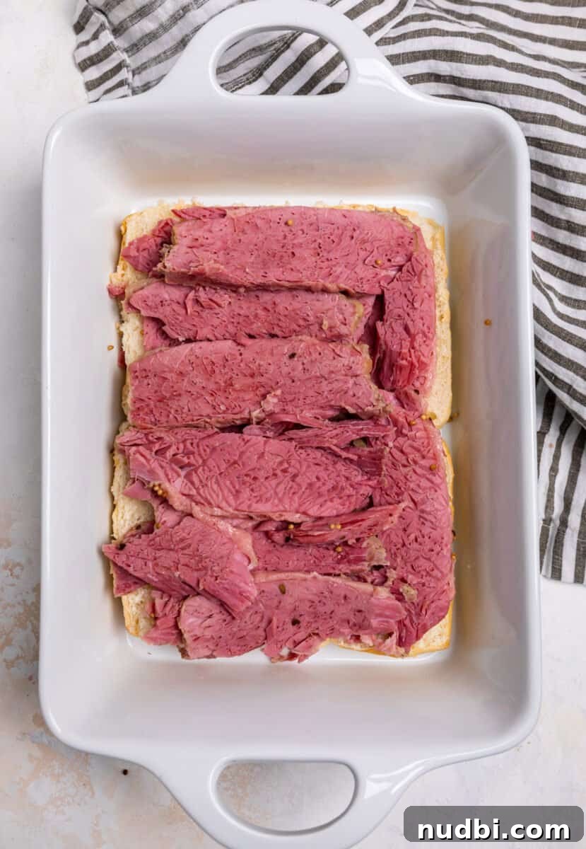 Classic Reuben Sliders with Melted Swiss and Tangy Sauerkraut 6 Corned beef sliced and layered on top of rolls.