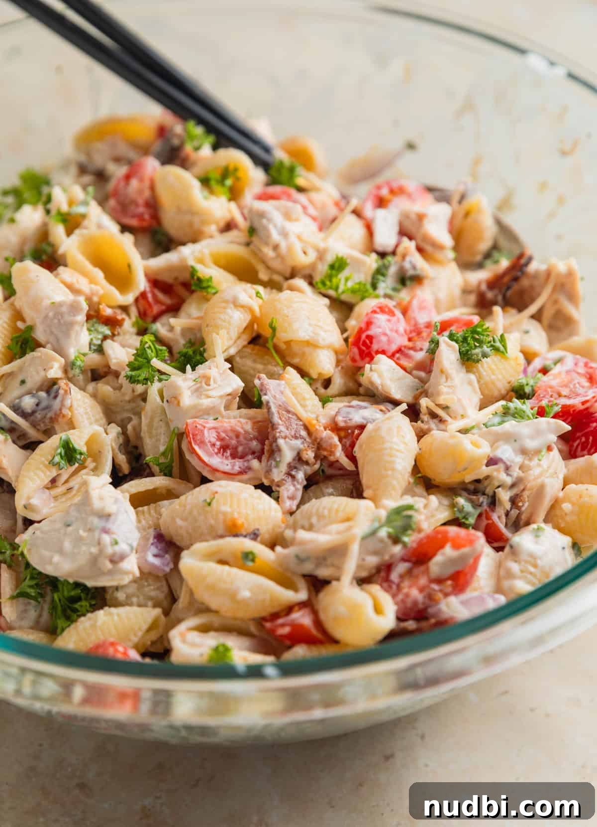 Chicken, Bacon & Ranch Pasta Salad Recipe for Summer Meals 8 Ranch tossed with noodles, chicken, bacon and other ingredients in glass bowl.