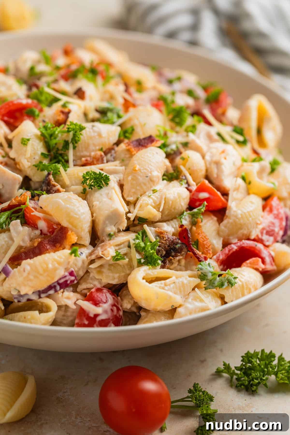 Chicken, Bacon & Ranch Pasta Salad Recipe for Summer Meals 10 Dish with chicken bacon pasta salad topped with chopped parsley.