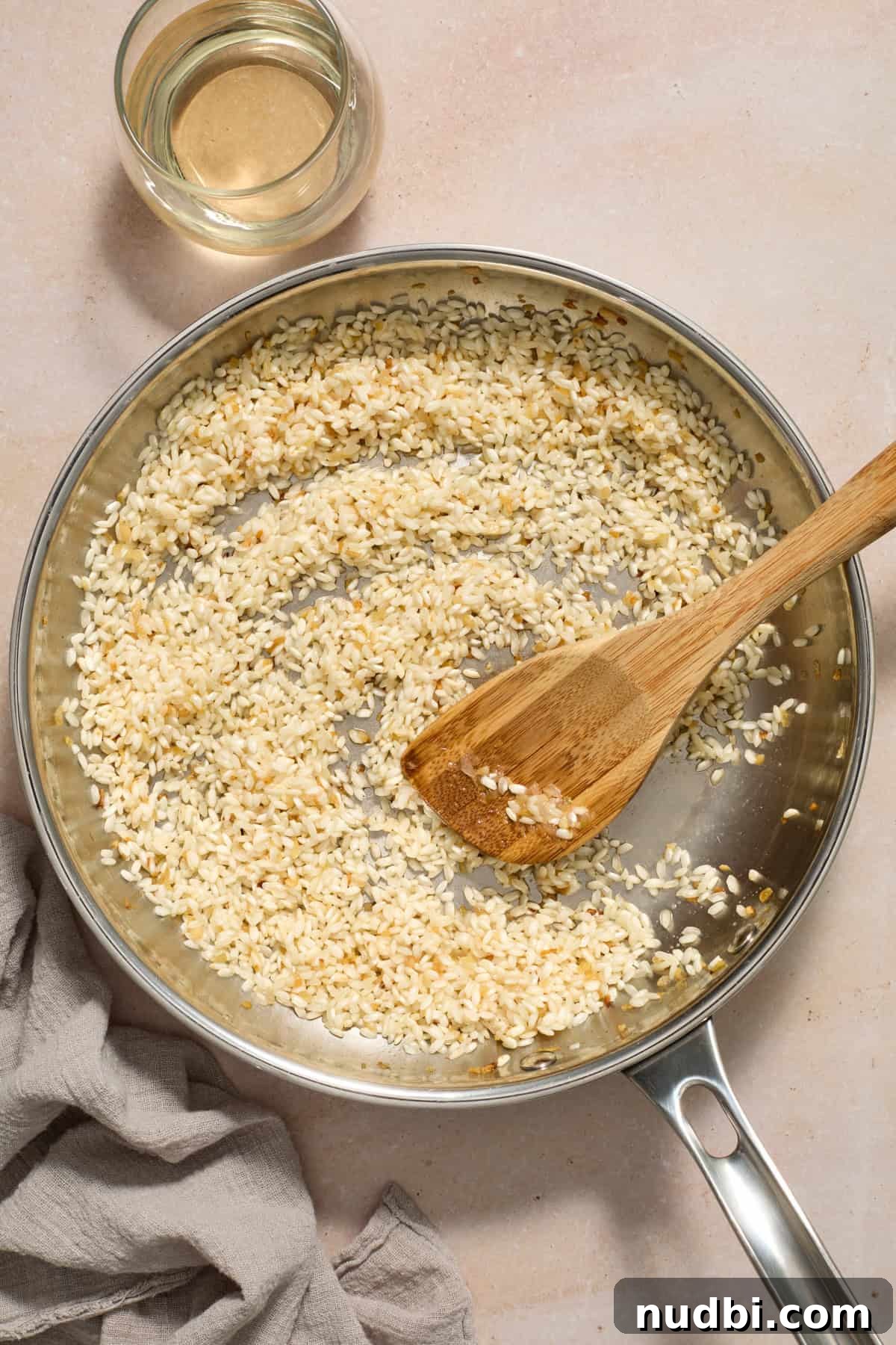 Creamy Spring Risotto with Peas and Asparagus 7 Risotto ingredients being stirred in pan before broth is added.