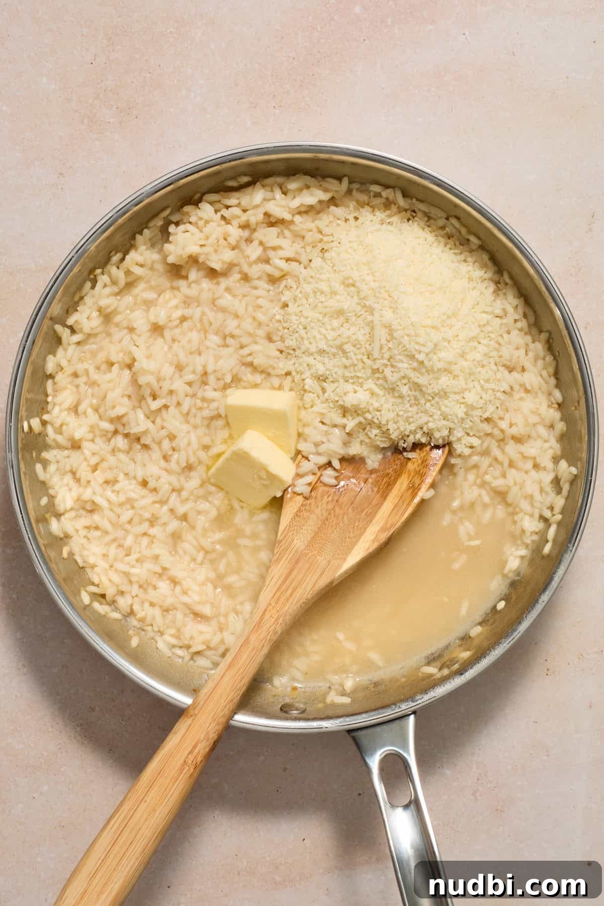 Creamy Spring Risotto with Peas and Asparagus 10 Parmesan cheese and butter added to risotto in pan.
